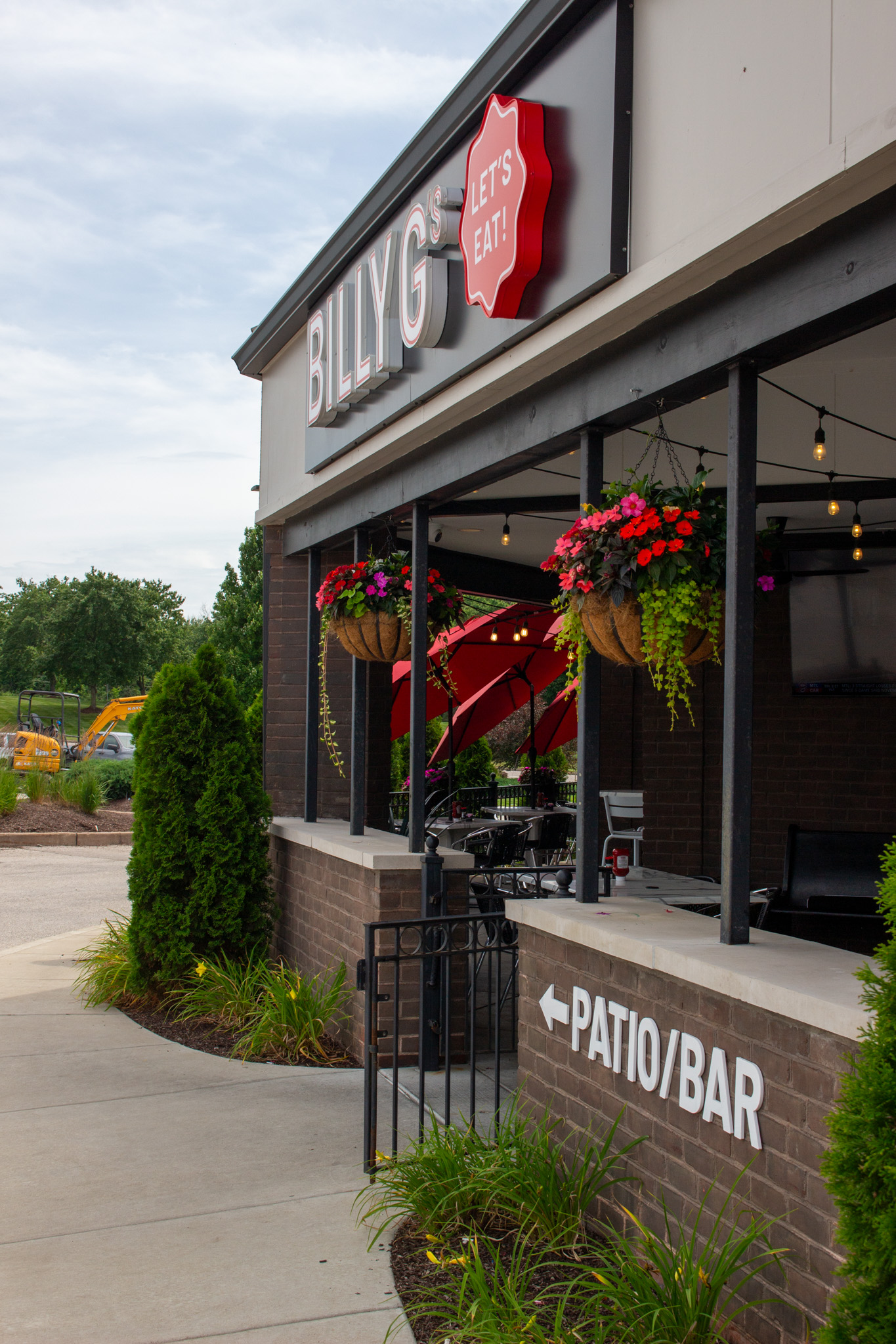 Patio, hanging plants, red umbrellas, Billy G's sign